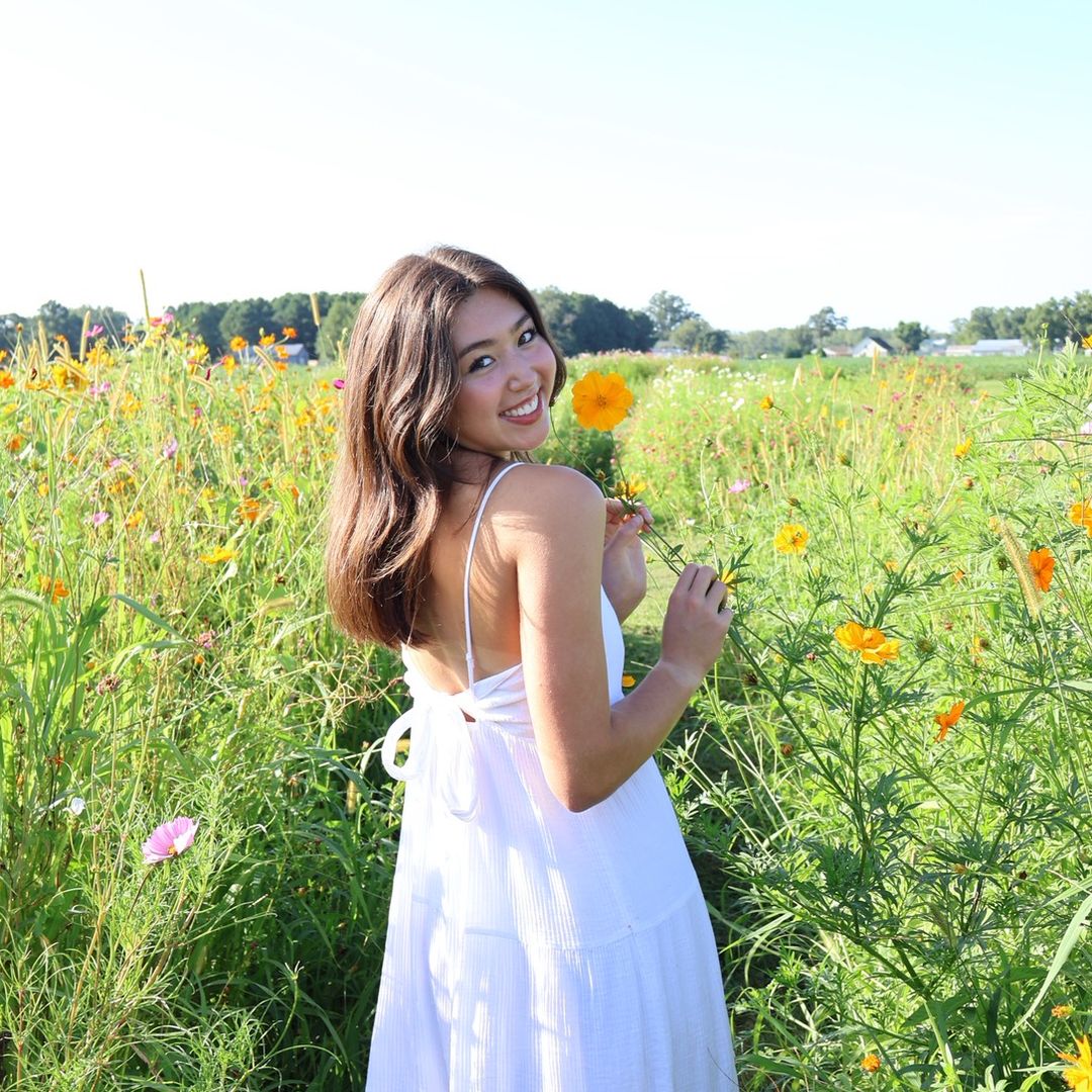 Eliana outside in a field of flowers
